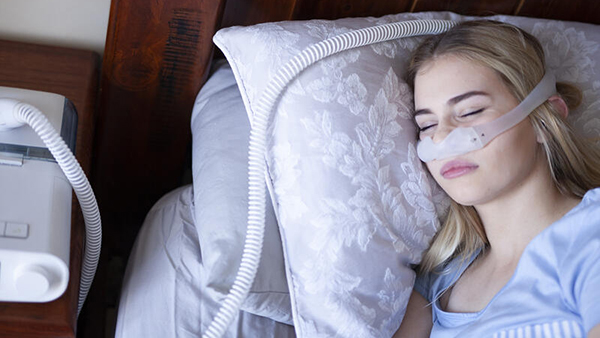 Woman sleeping with CPAP machine