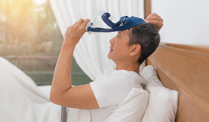 person putting on a cpap machine before bed
